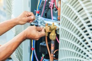 Technician repairing HVAC unit.