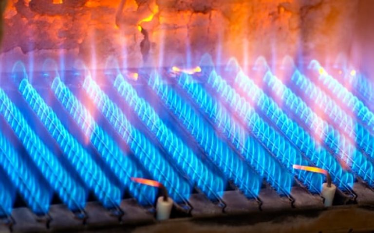Gas furnace burner in operation with blue flames