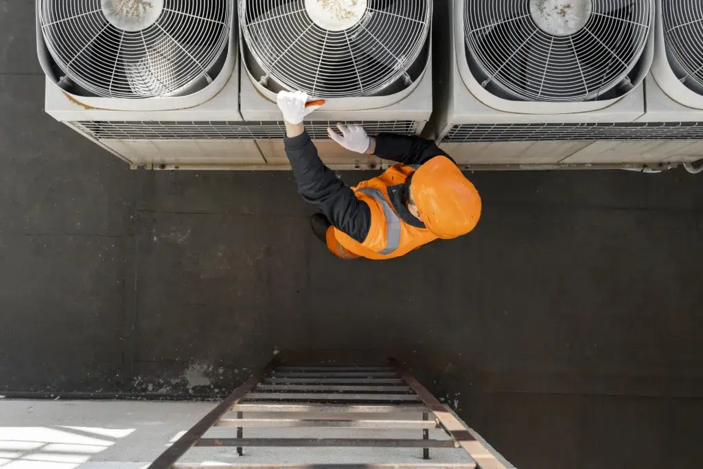 Worker servicing rooftop air conditioning units.