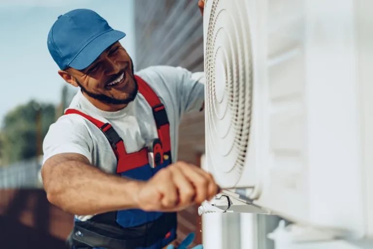 Young black man repairman checking an outside air conditioner unit