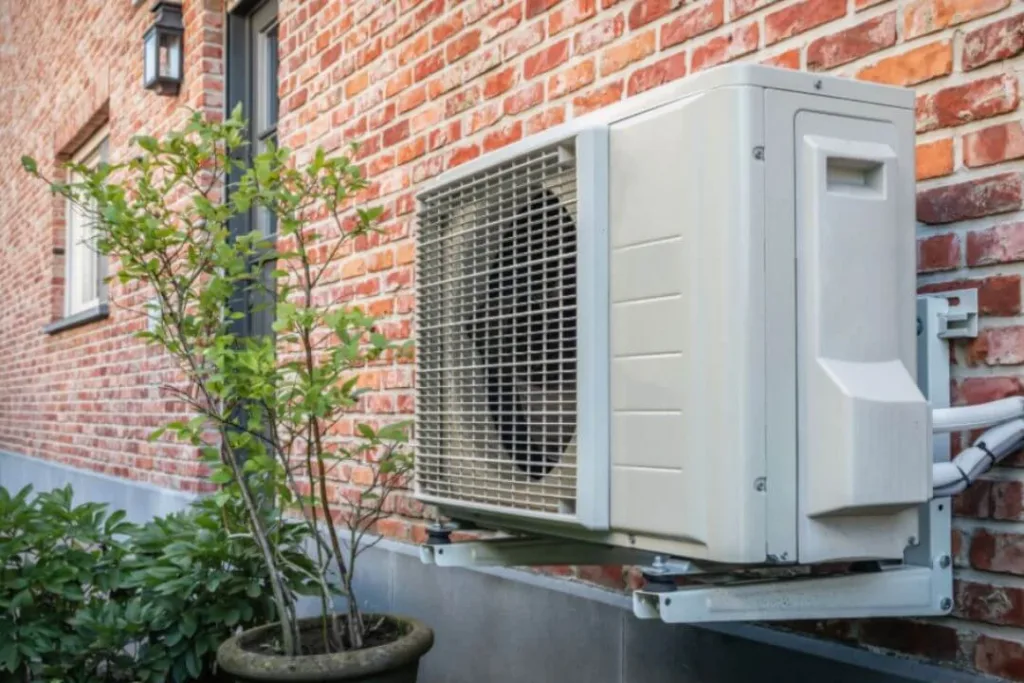 Outdoor heat pump unit mounted on wall.