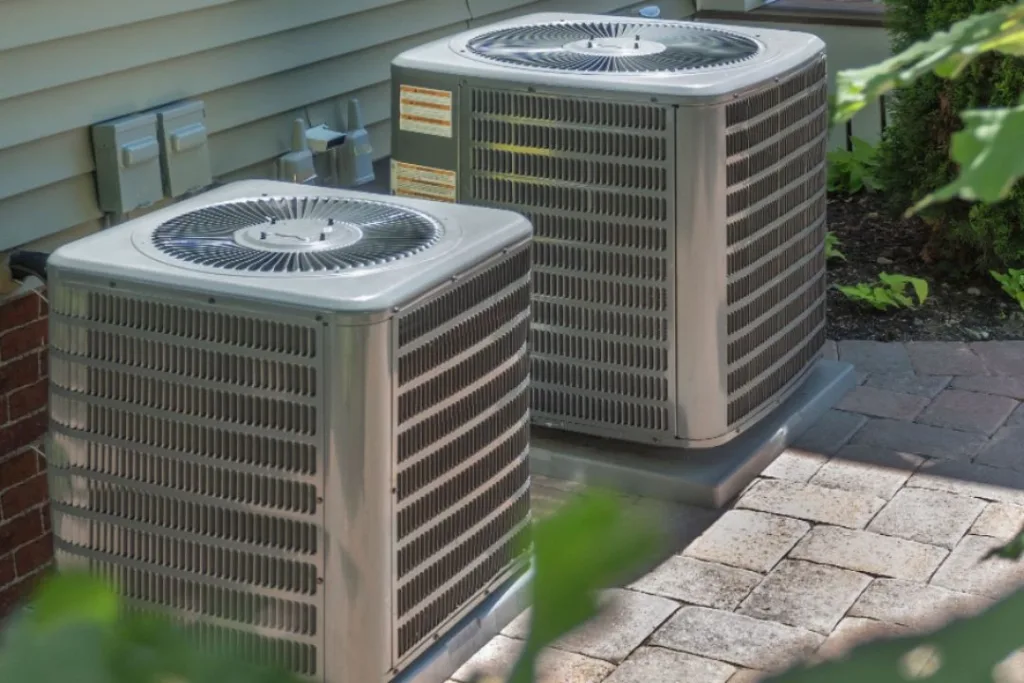 Twin residential air conditioning units outside.