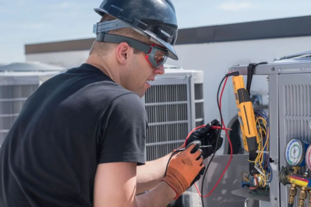 Technician testing electrical components on HVAC unit.