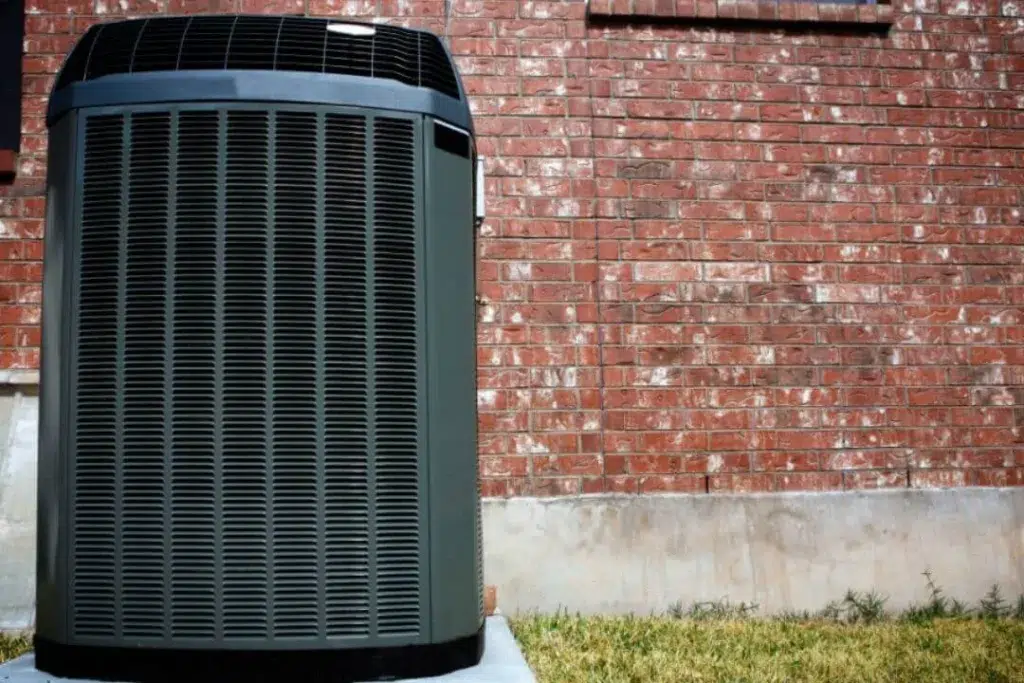 Outdoor air conditioning unit near brick wall.