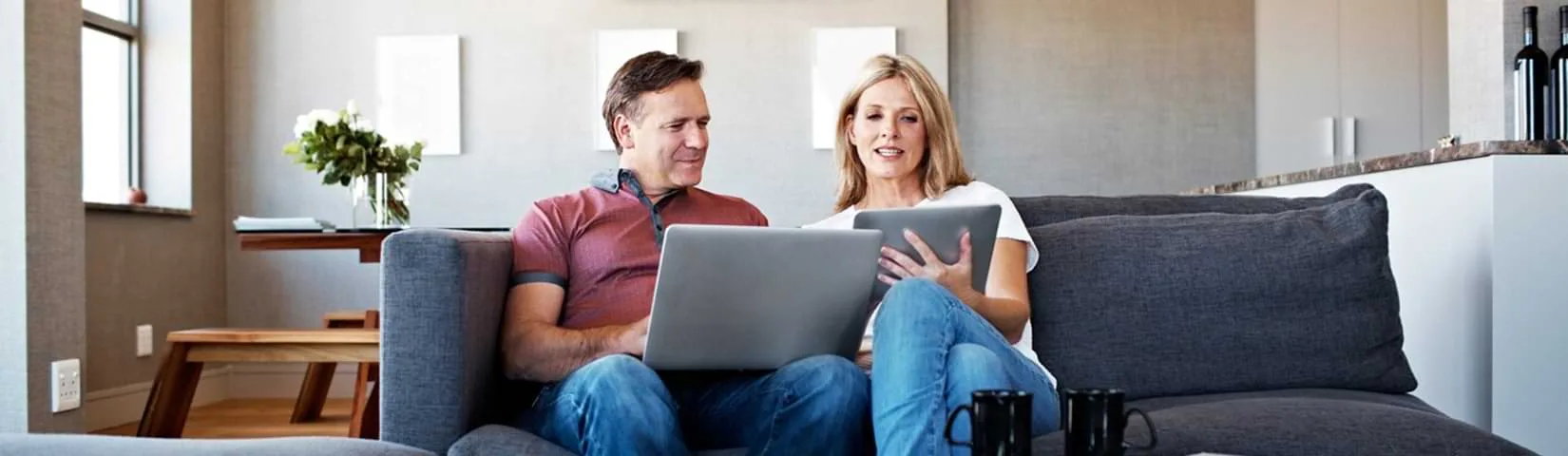 Couple using laptop and tablet.