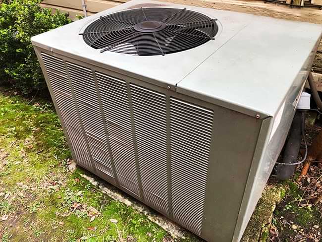 Residential HVAC outdoor unit in a backyard setting