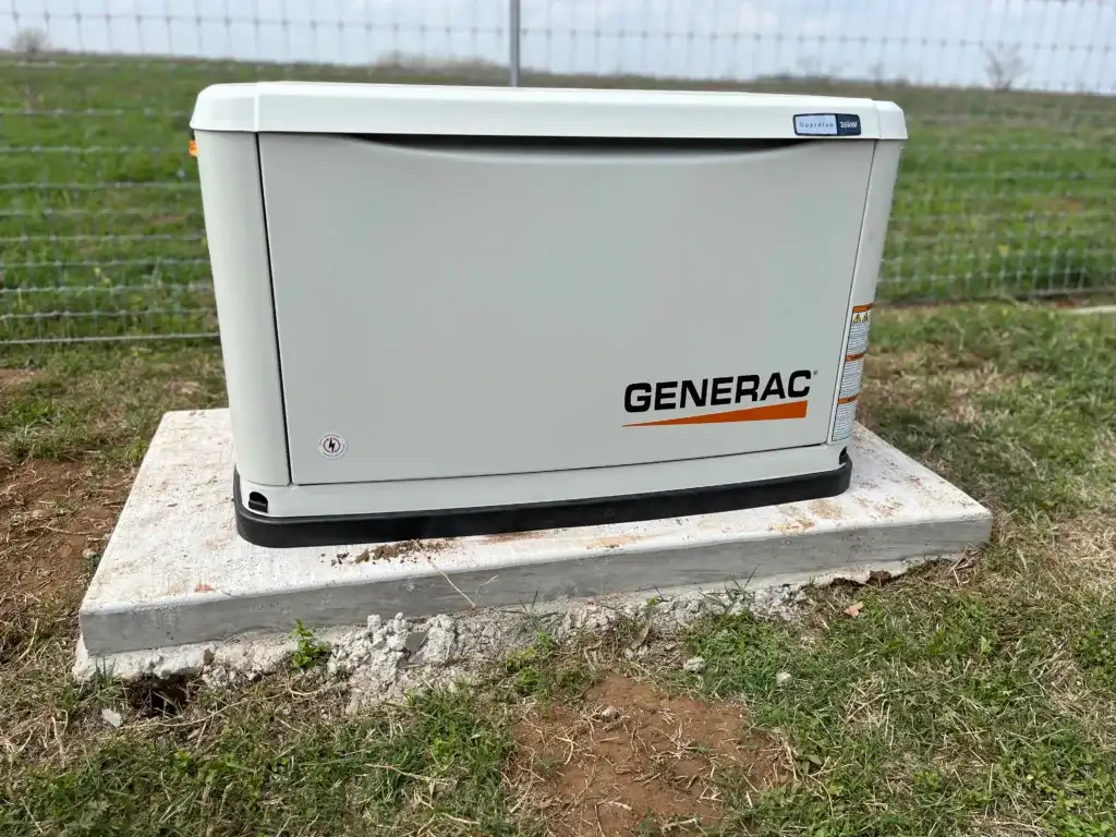 A white Generac standby generator installed on a concrete platform outdoors
