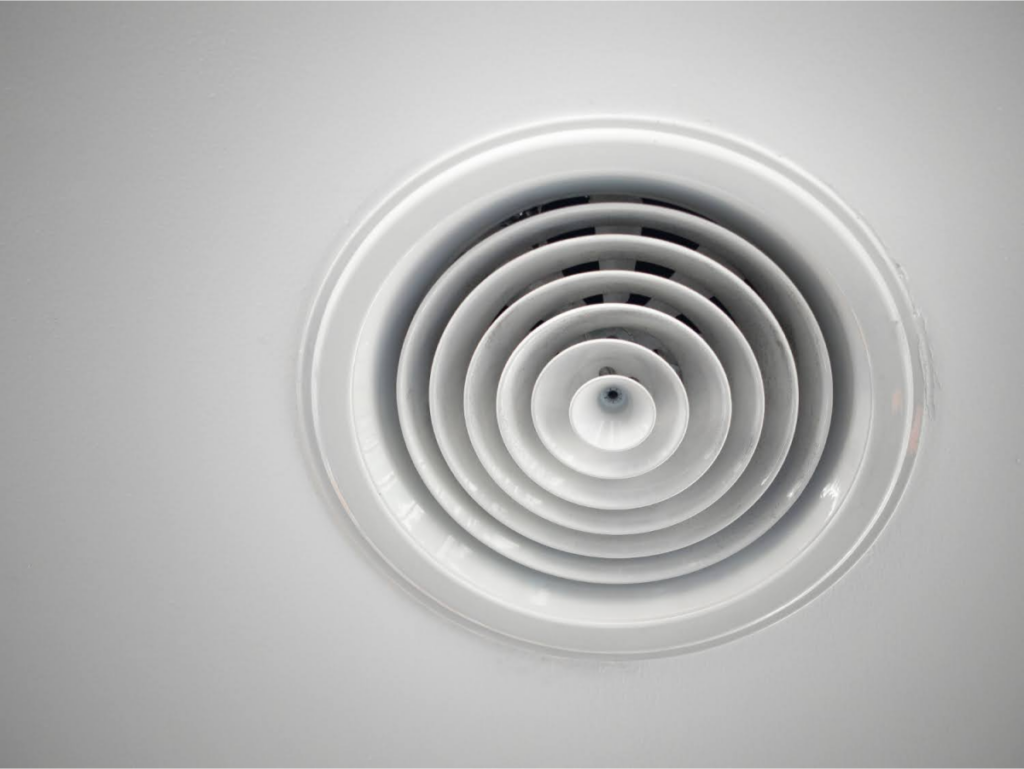 A circular ceiling vent with concentric rings.