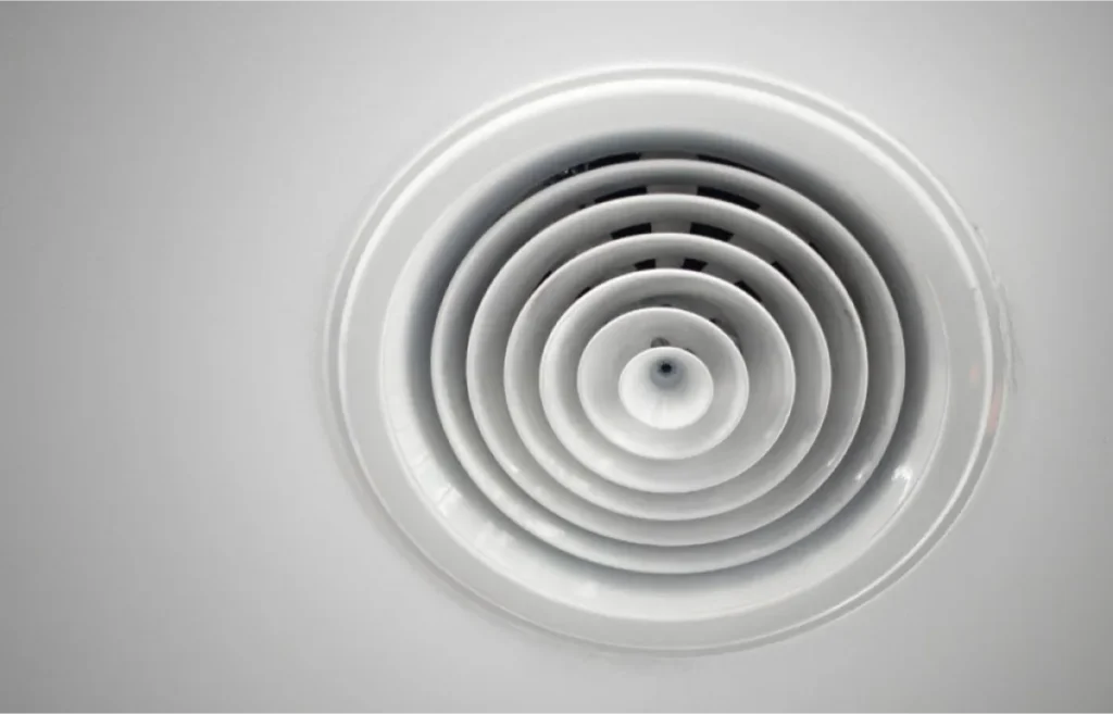 A circular ceiling vent with concentric rings.