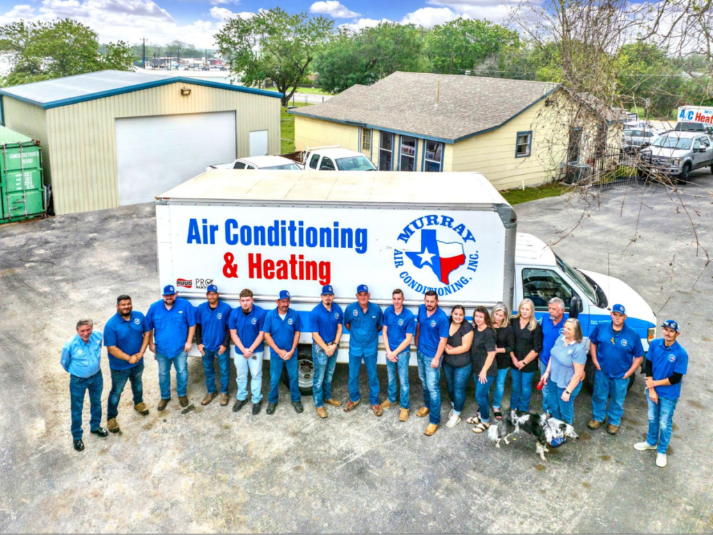 Group of HVAC technicians in front of a branded truck.