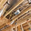 Exposed ceiling showing the electrical components of the light as well as air ducts made out of foil.