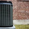 a black heater on a concrete platform next to a brick wall